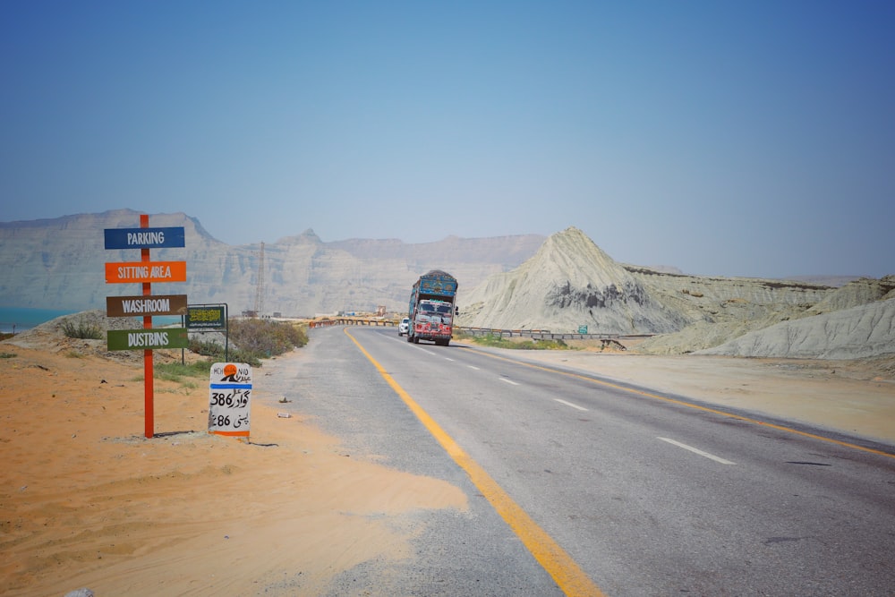 a double decker bus driving down a desert road