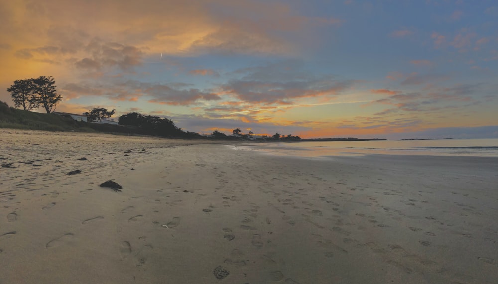 a sandy beach with footprints in the sand