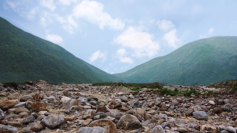 a rocky area with mountains in the background