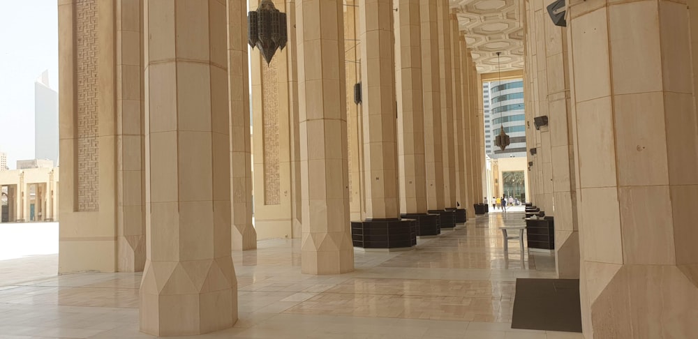 un couloir avec des colonnes et une horloge sur le mur