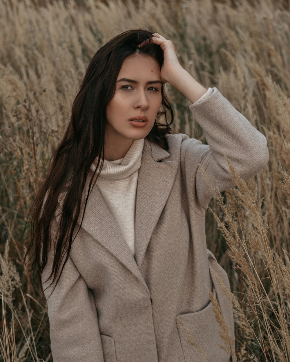 a woman standing in a field of tall grass