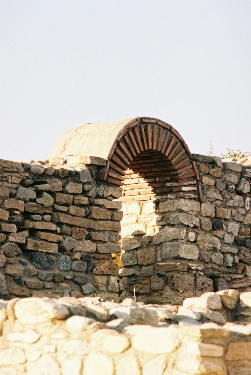 a stone wall with a circular doorway in the middle of it