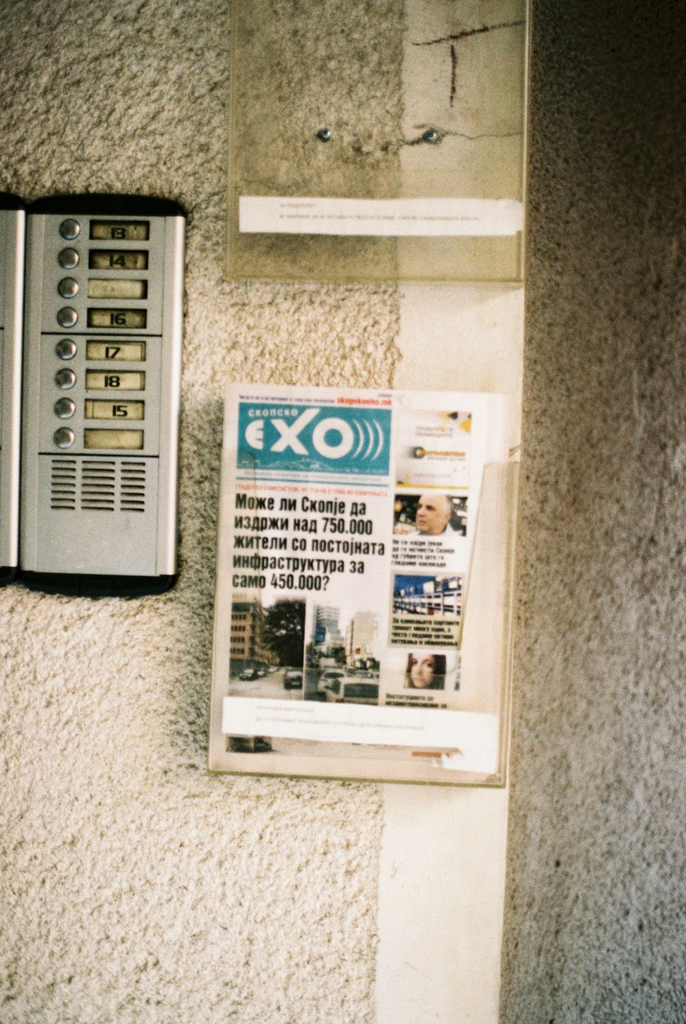 a newspaper is laying on the wall next to a telephone