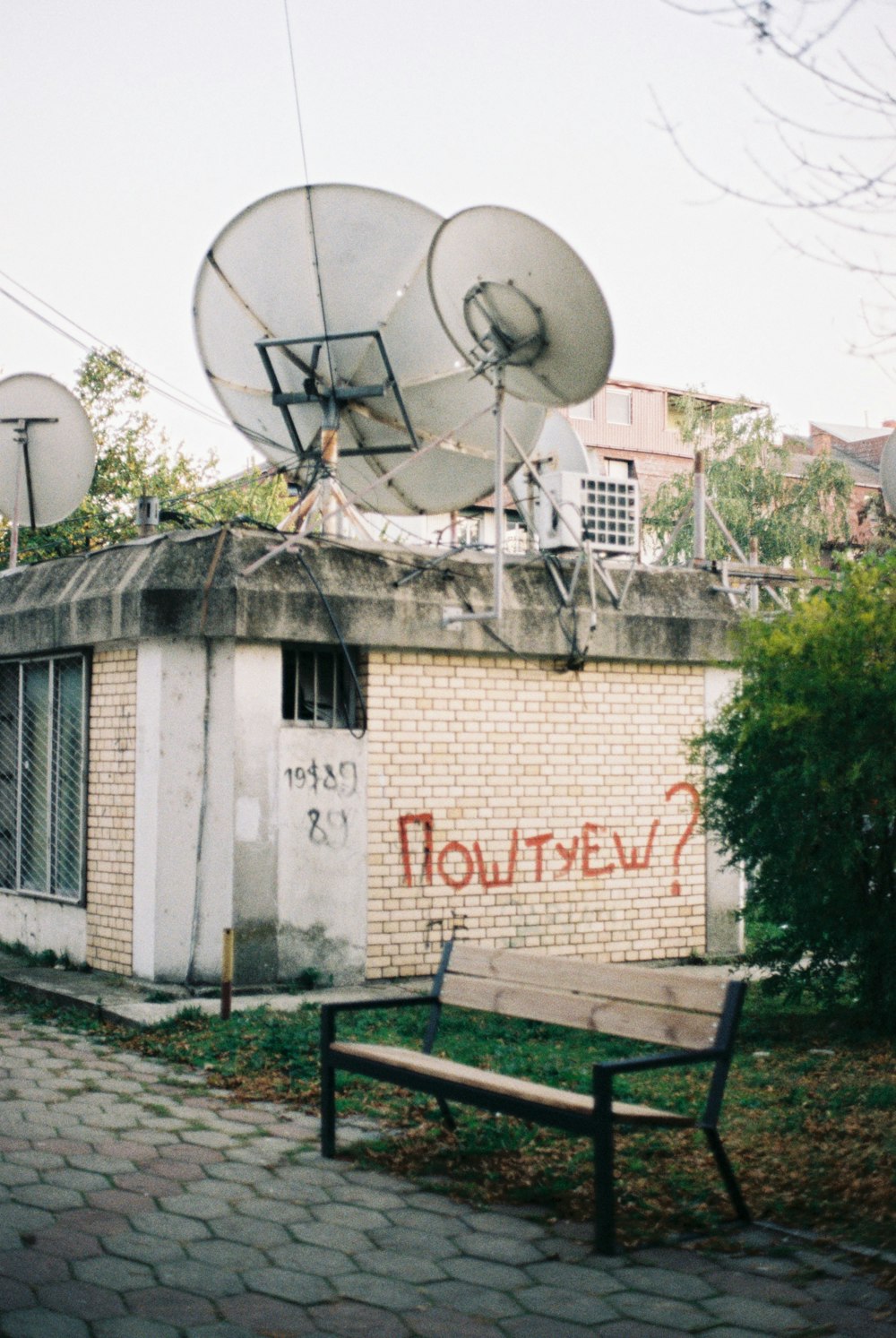 a satellite dish sitting on top of a building next to a bench