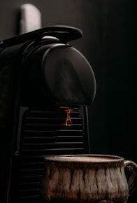 a coffee maker with a cup next to it