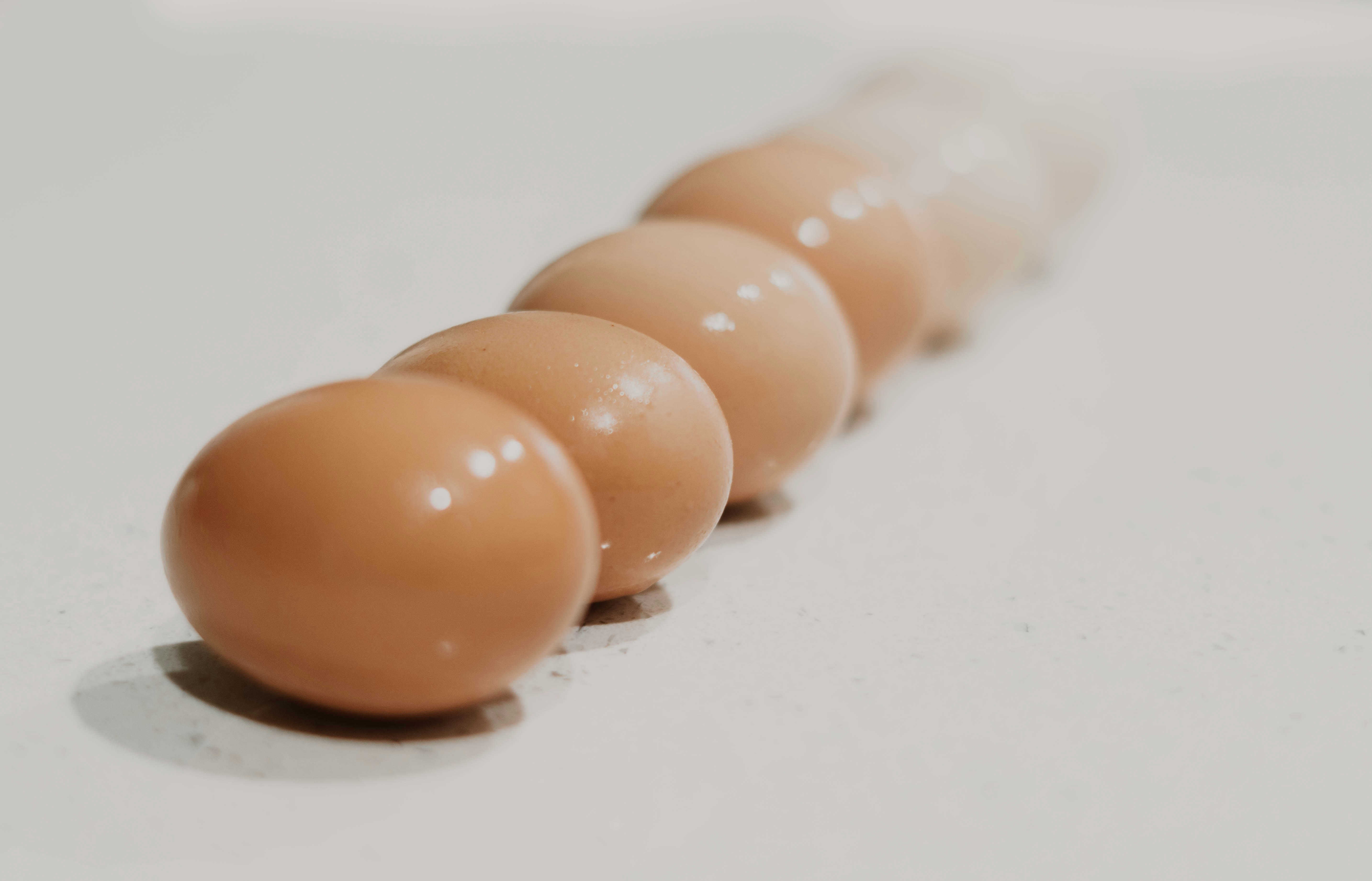 a row of brown eggs sitting on top of a white counter