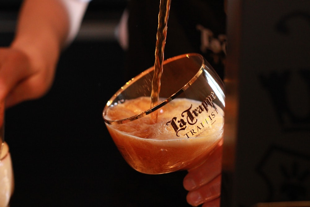 una persona vertiendo una bebida en un vaso