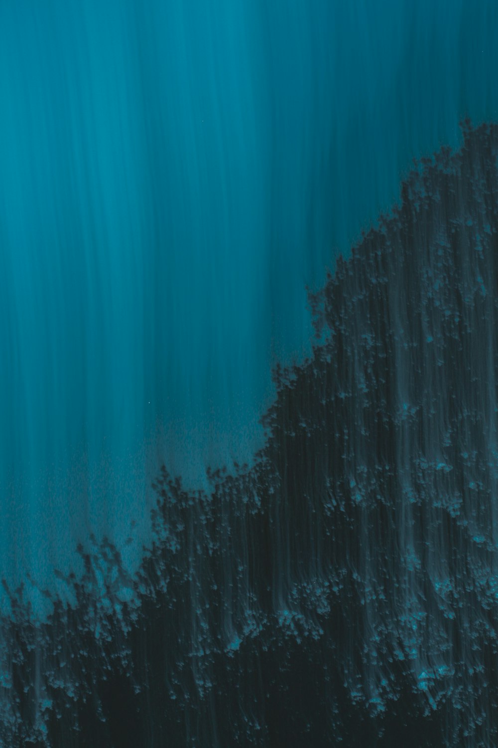 Une photo bleue et noire de l’eau et des rochers