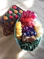 A colorful collection of hand-sewn French scrunchies displayed on a wooden table.