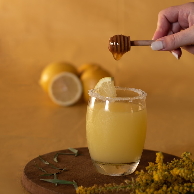 a person is dipping a lemon into a glass