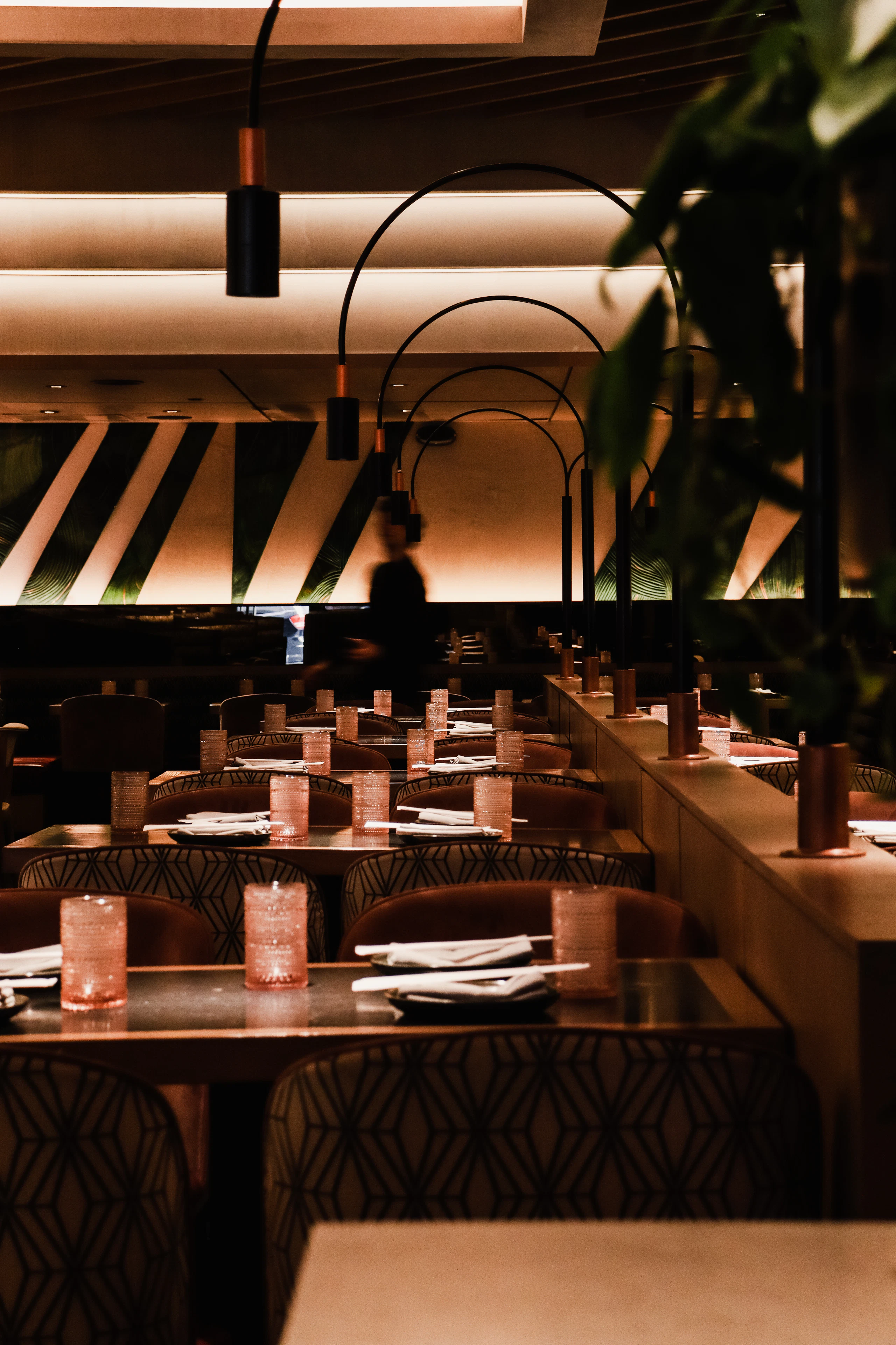 A low-lit dining room under a slatted timber ceiling