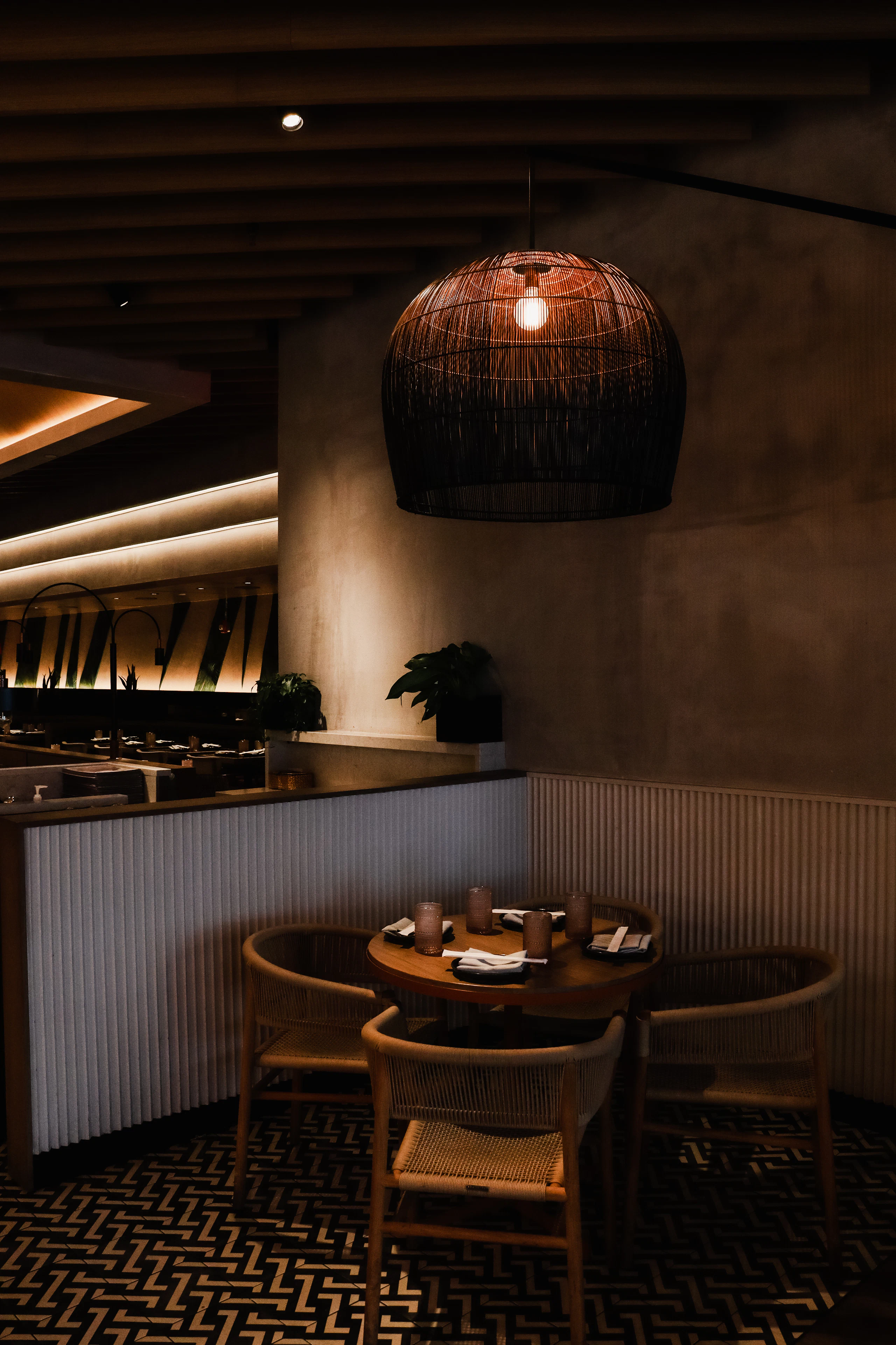 A dark bar interior with warm wall lighting