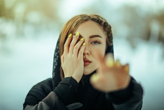 a woman holding her hands up to her face