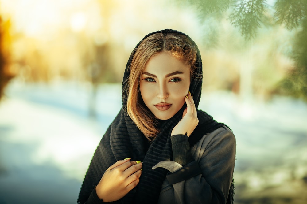 a woman wearing a black scarf and a black jacket