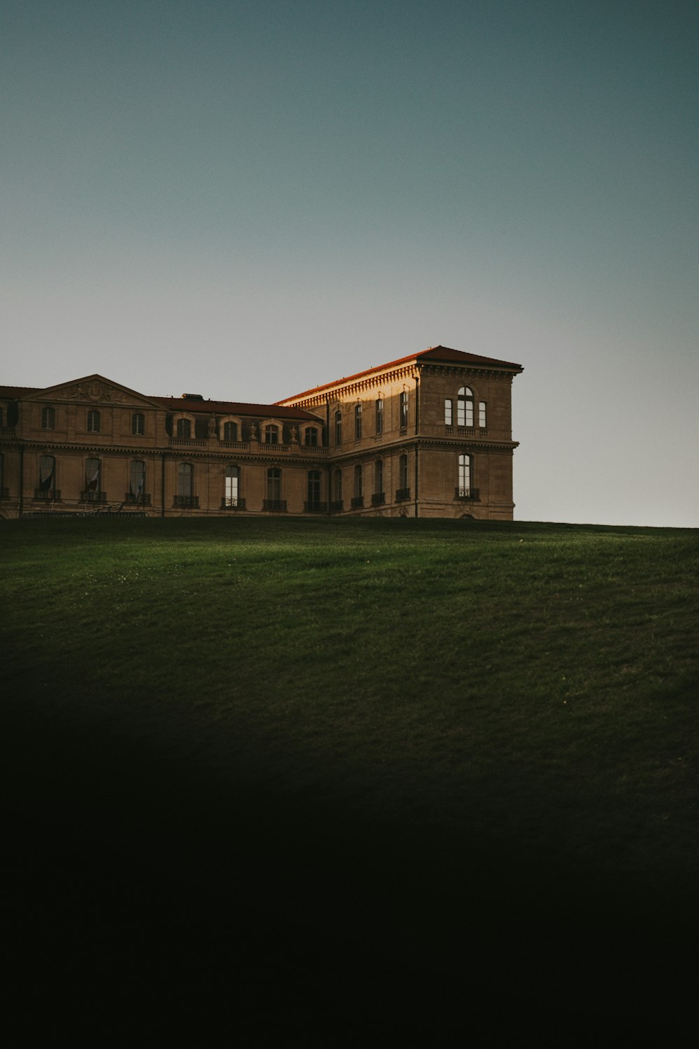 a large building sitting on top of a lush green field