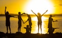 a group of people standing next to a body of water