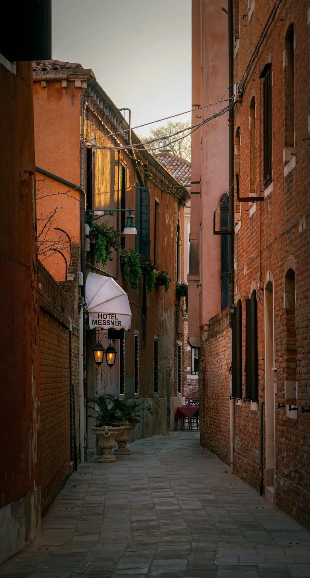 a narrow alley way with a lamp hanging from it's side