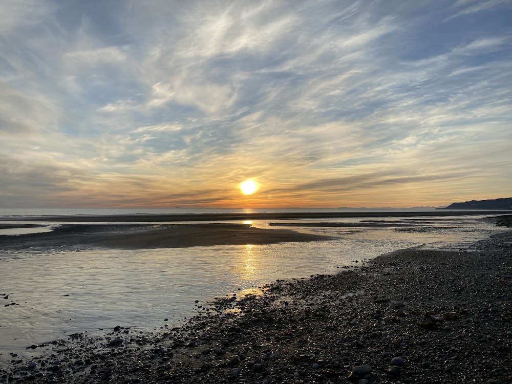 the sun is setting over a body of water