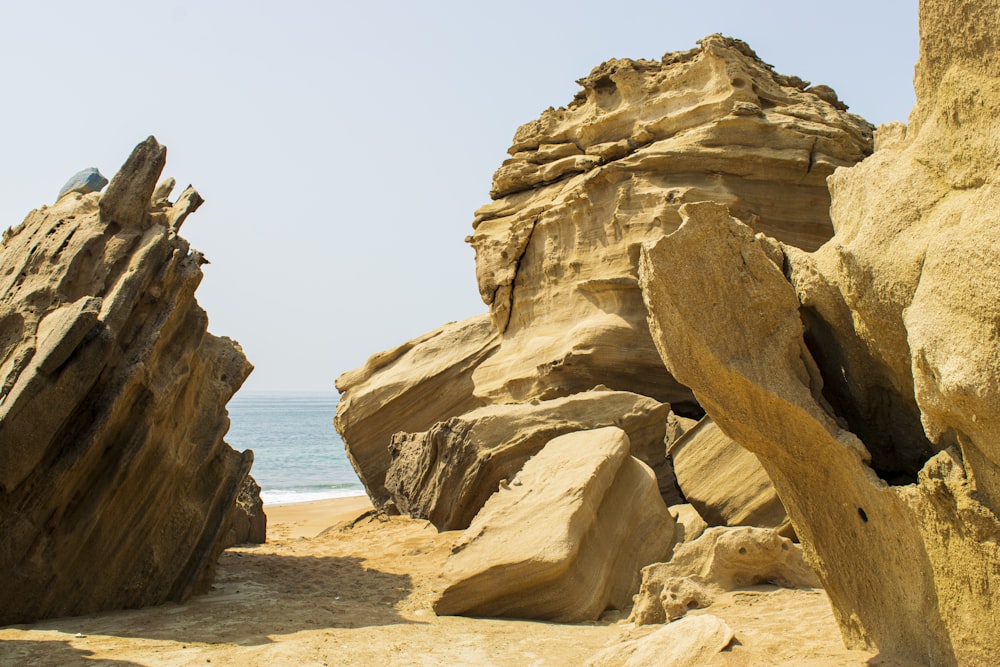 a large rock formation on a beach near the ocean
