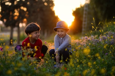 a couple of kids that are sitting in the grass