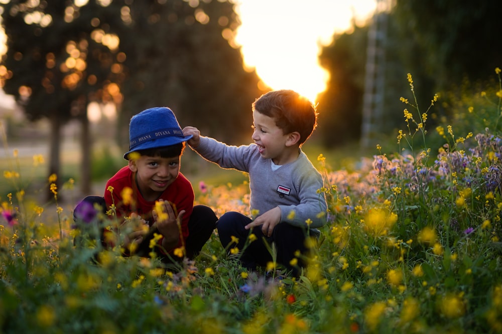 two young boys playing in a field of flowers