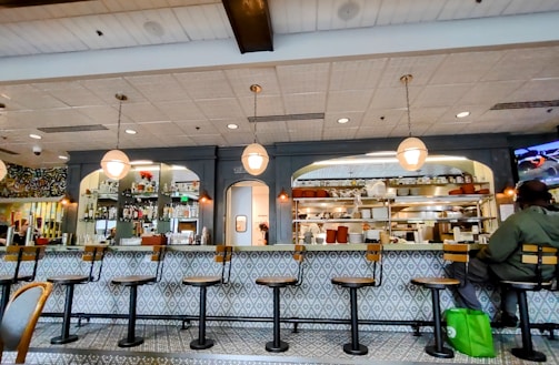 A cozy restaurant counter with a friendly staff member ready to assist customers.