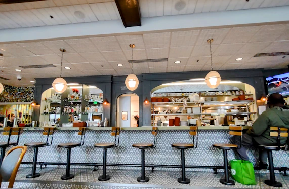 A cozy restaurant counter with a friendly staff member ready to take orders.