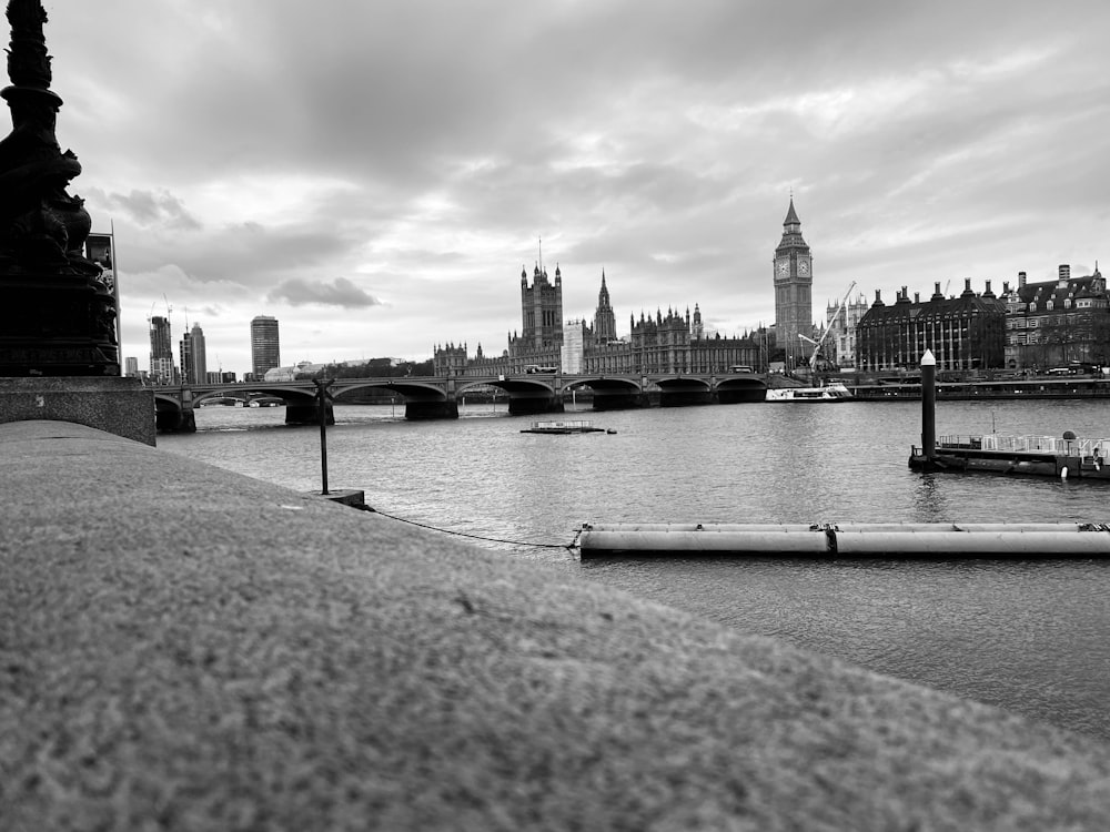 a black and white photo of a river and a bridge