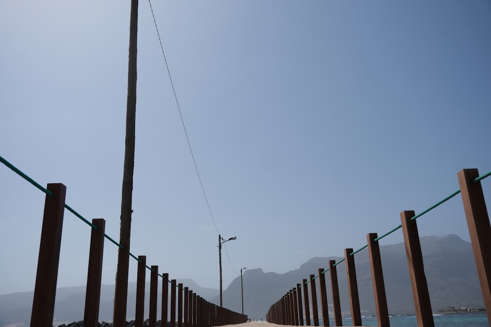 a long wooden fence with a street light on top of it