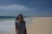 a woman standing on a beach next to the ocean