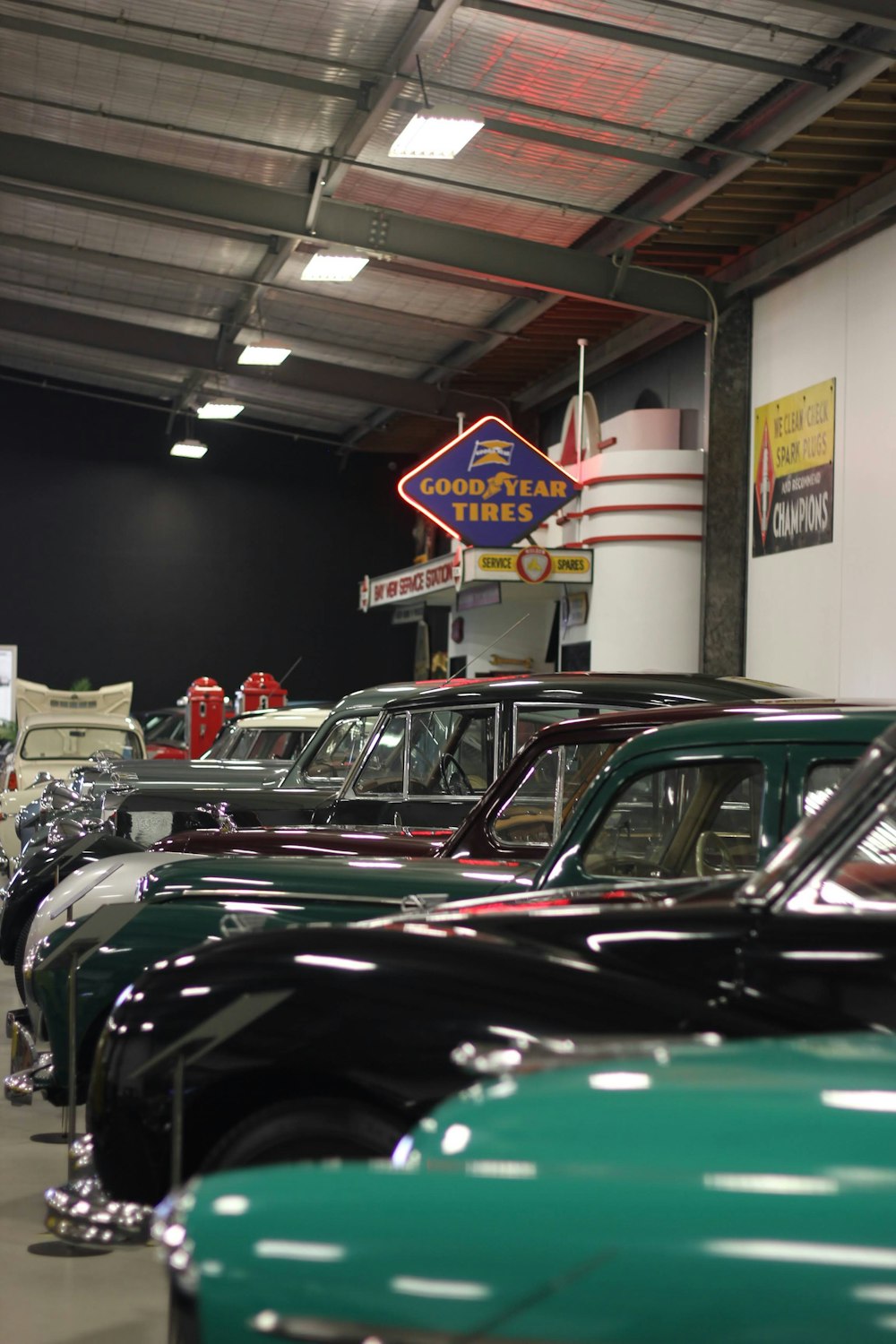 a row of classic cars parked in a garage