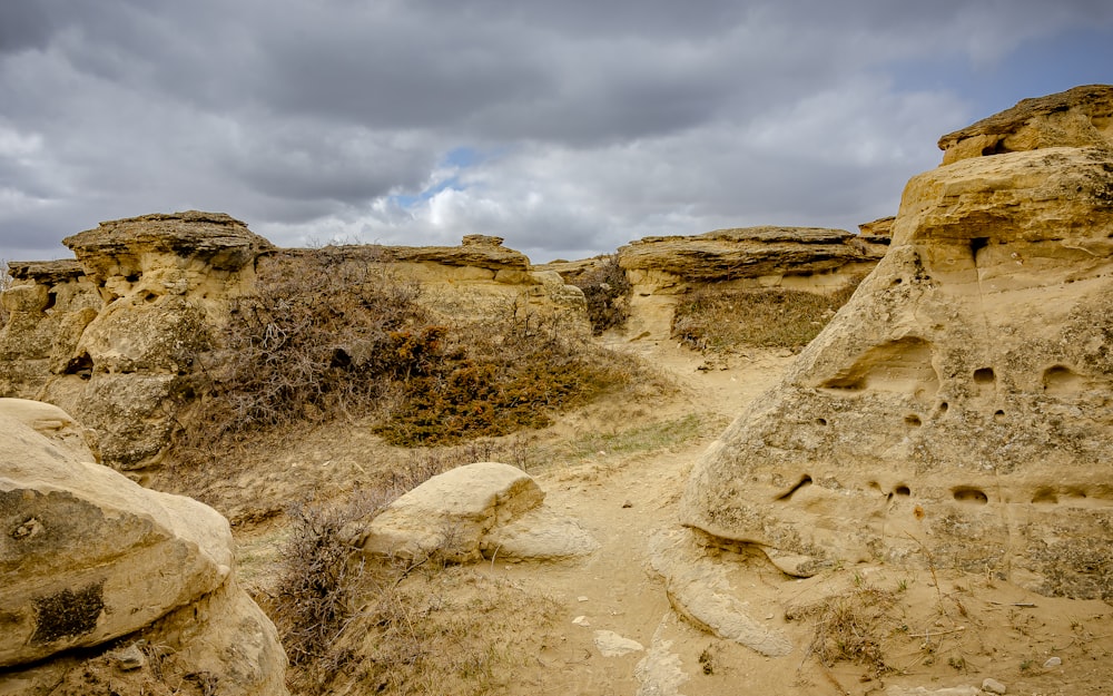 a group of rocks in the desert under a cloudy sky