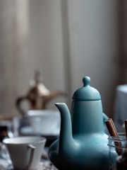 a blue teapot sitting on top of a table