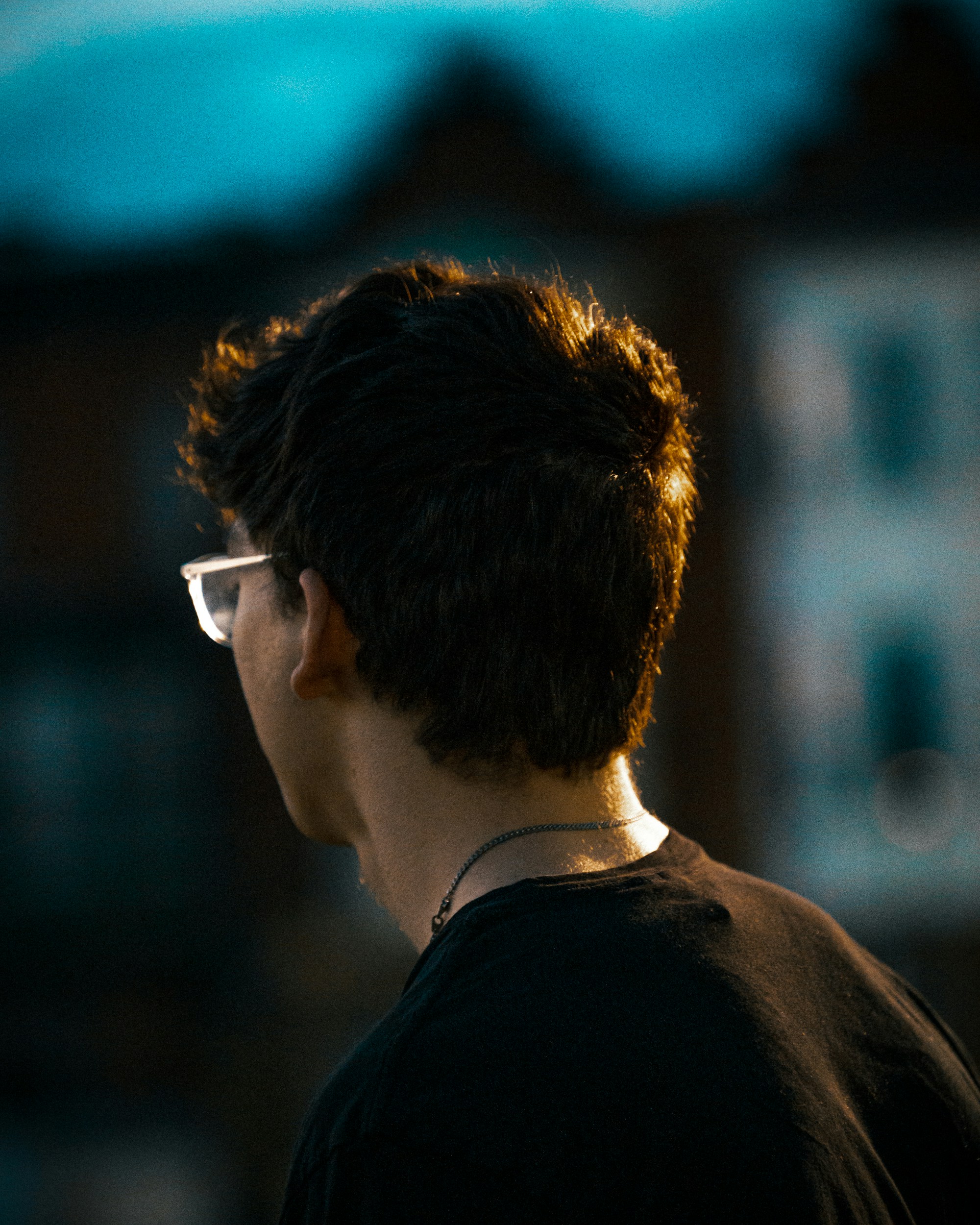 a man wearing glasses looking off into the distance