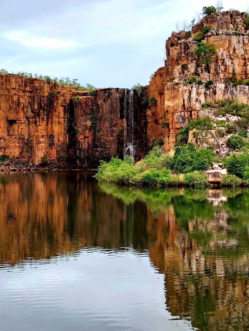 a body of water with a waterfall in the background