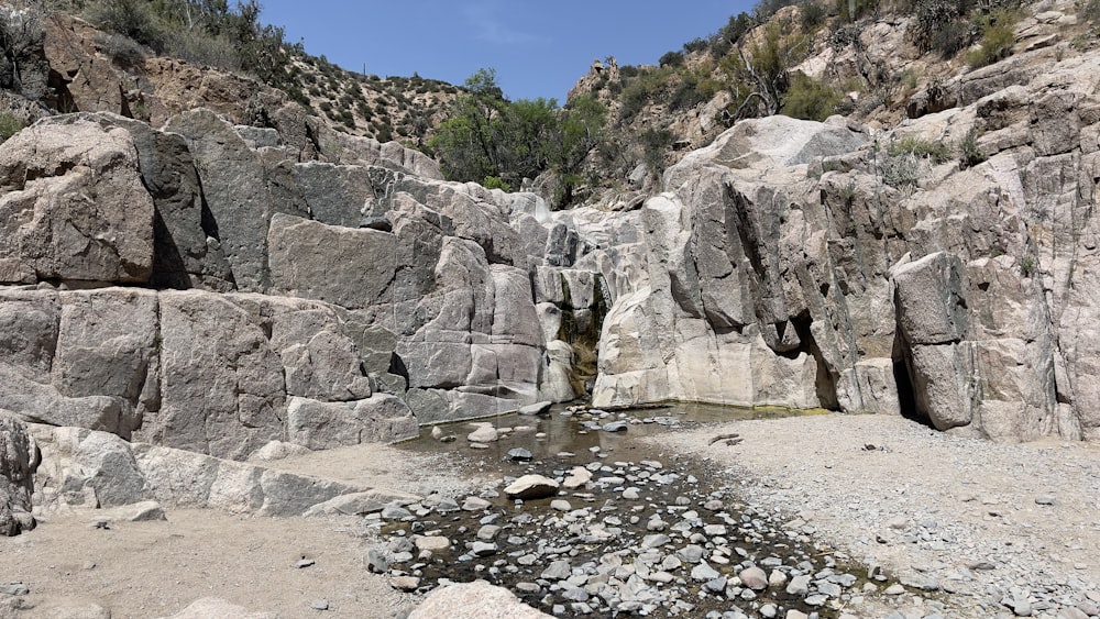 a rocky mountain with a small stream running through it