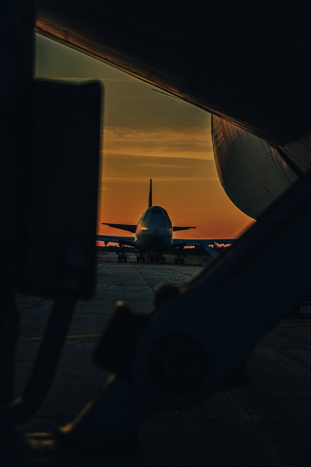 an airplane is sitting on the runway at sunset