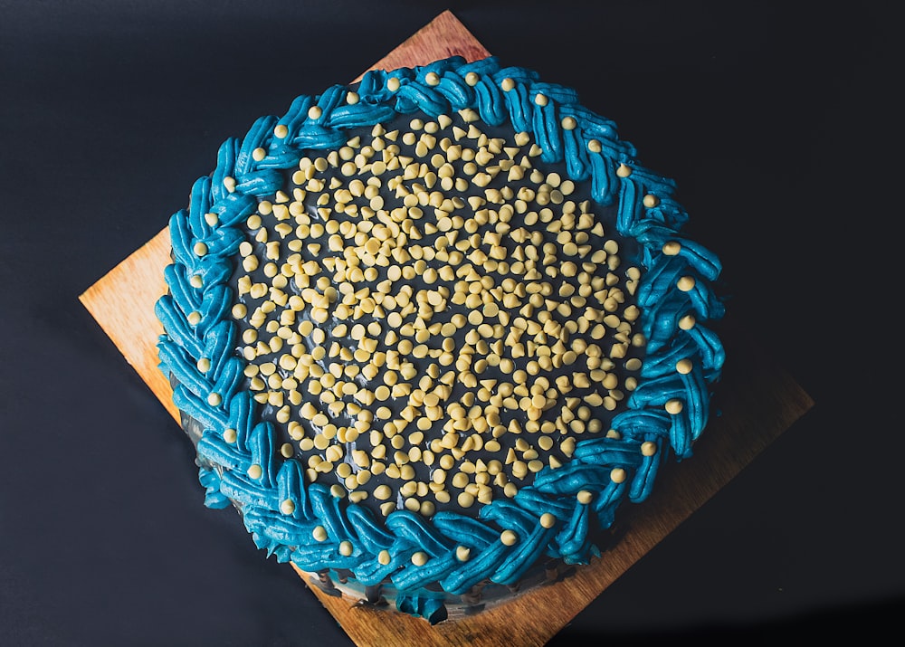 a blue and yellow cake on a wooden board