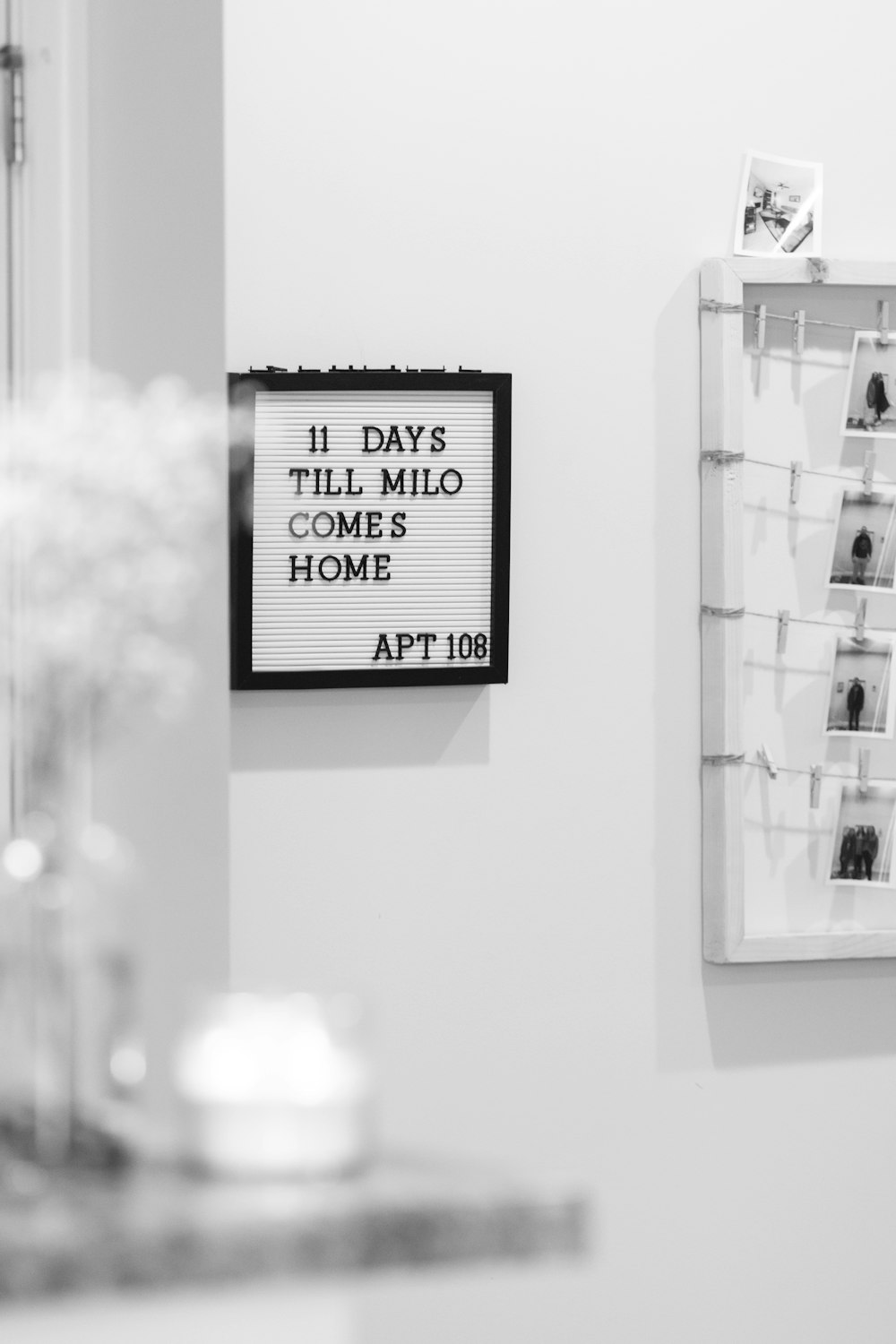 a black and white photo of a sign hanging on a wall