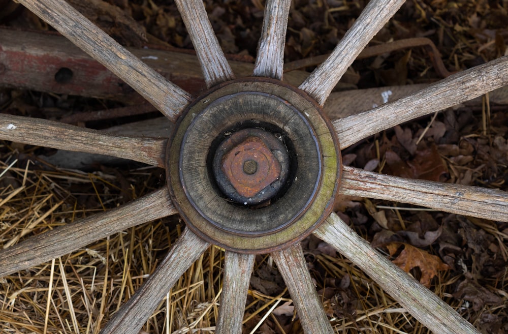 an old wooden wheel with a rusted spoke