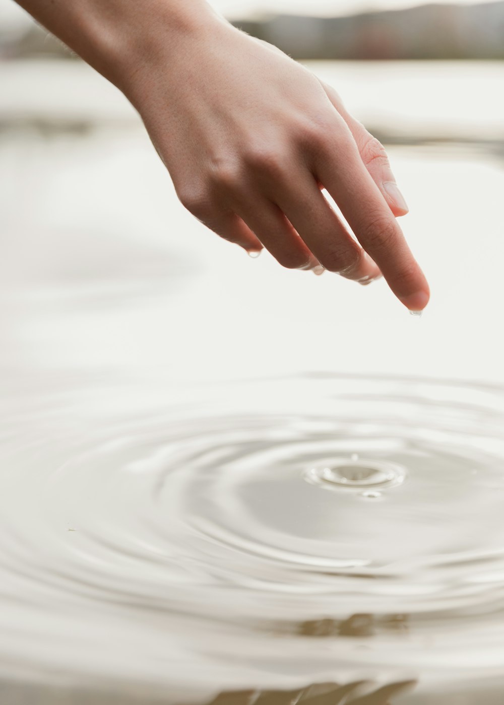 a person's hand reaching for a frisbee in the water