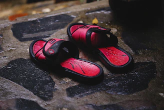 a pair of red shoes sitting on top of a stone floor