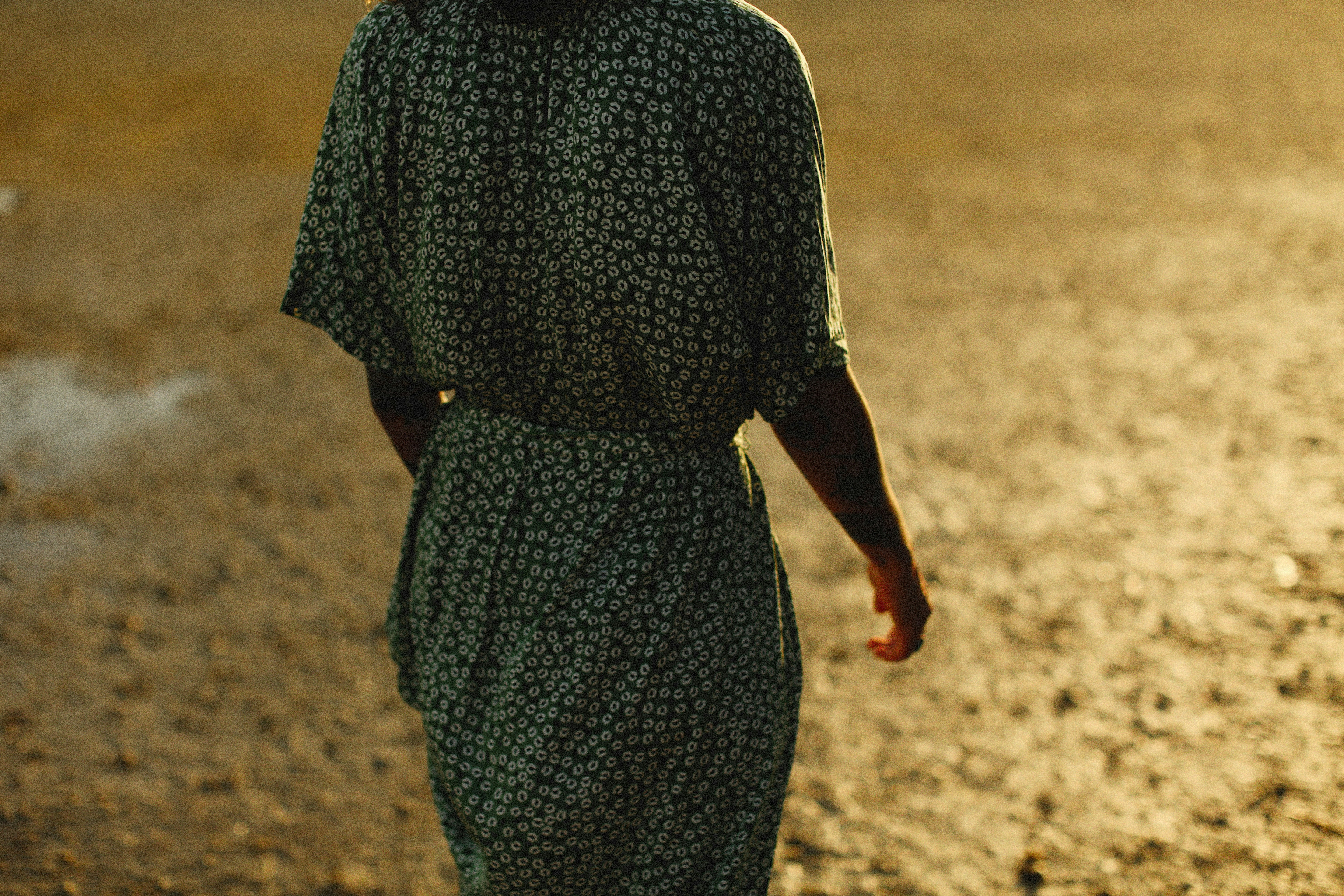 a woman in a green dress standing in a field