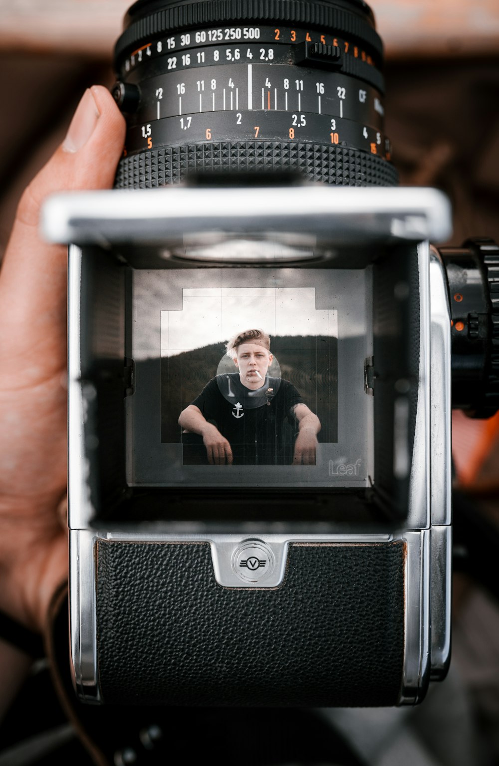 a person holding a camera with a picture of a man on it