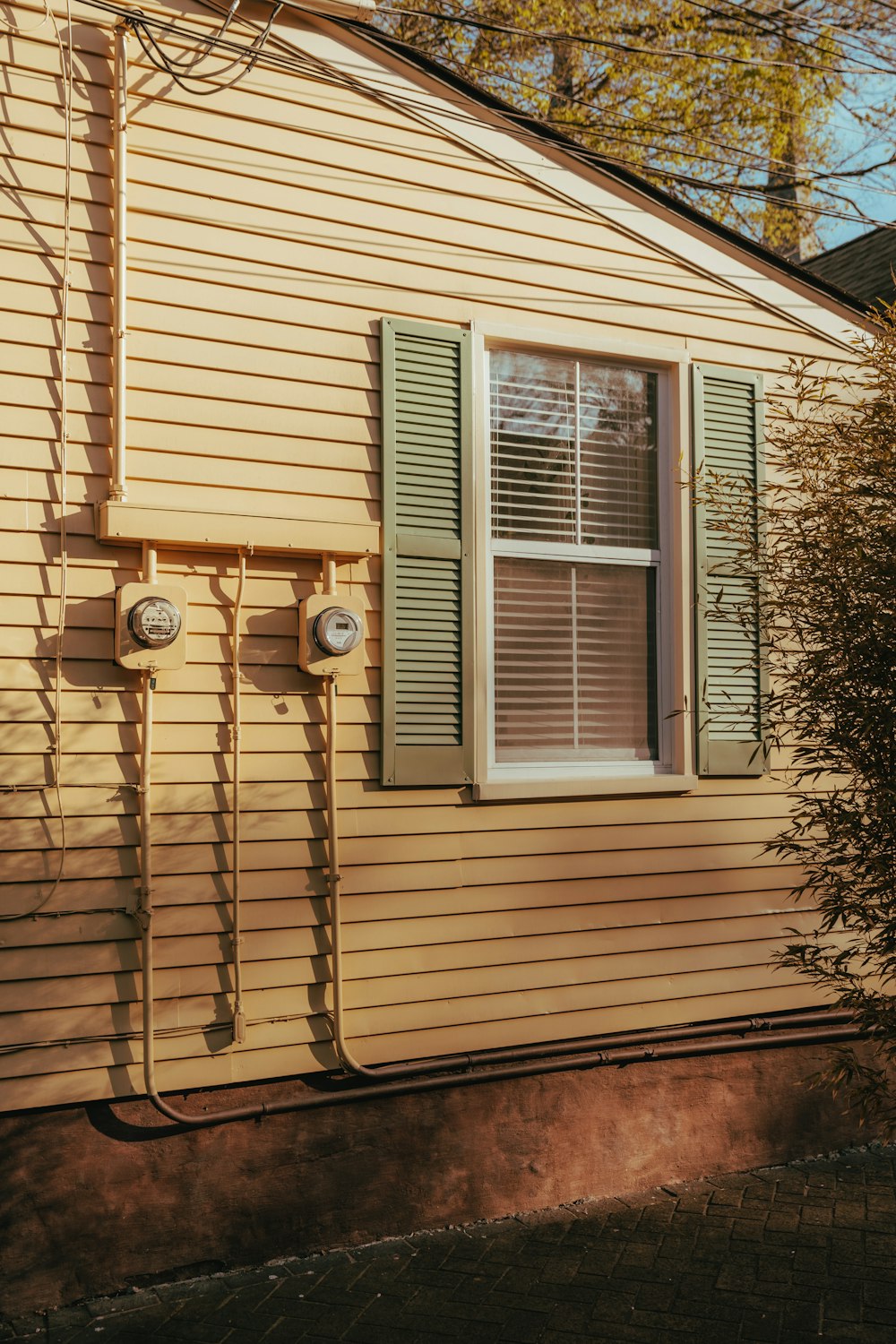 a yellow house with green shutters and a window