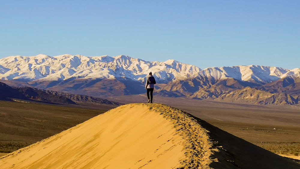 a person standing on top of a sand dune