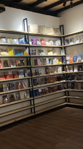 Brooke arranging a new shipment of books on wooden shelves.