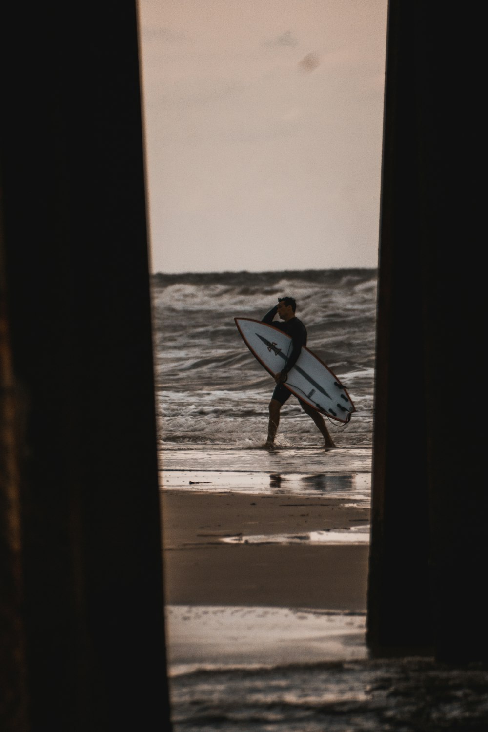 a man carrying a surfboard out of the ocean