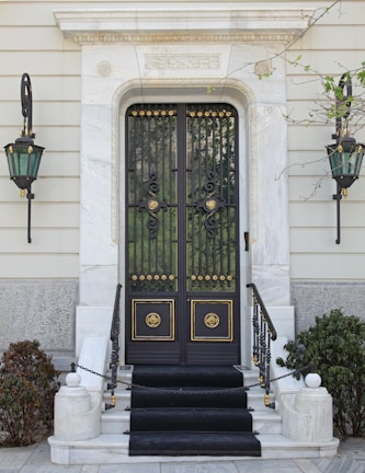 Close-up of an elegant entrance gate featuring sleek black and gold design.