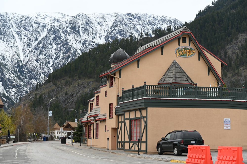 a car parked in front of a building with mountains in the background